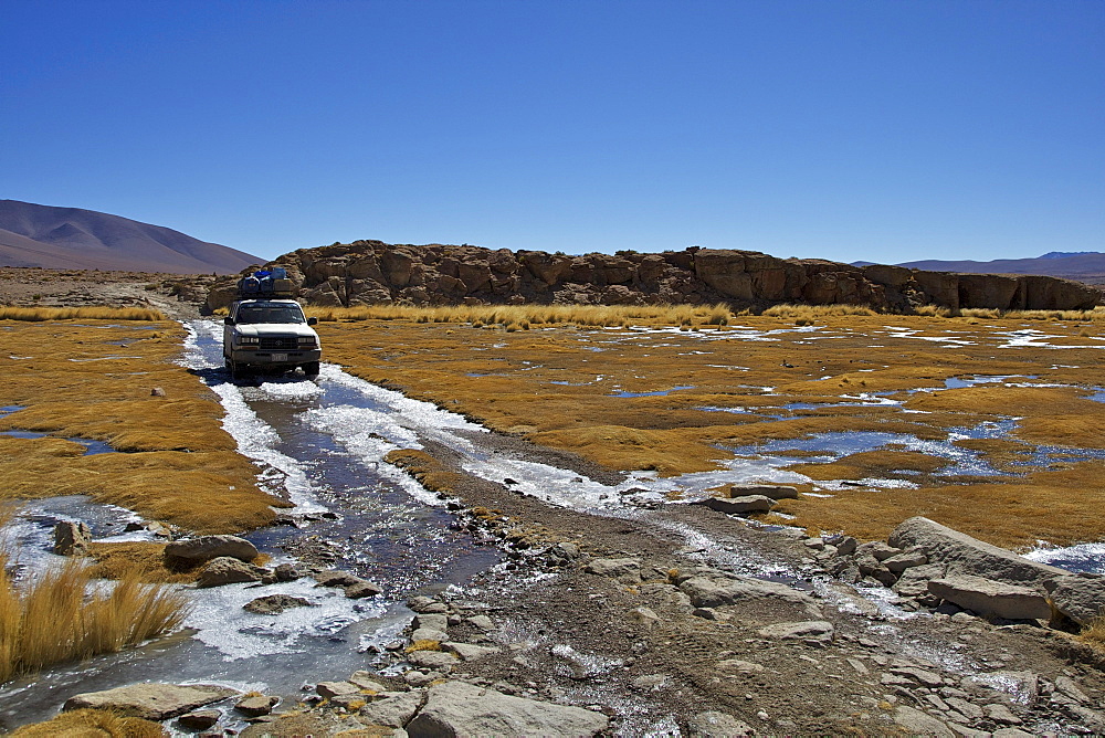 Off-road vehicle driving through an icy ford, Altiplano, Potosi, southern Bolivia, South America