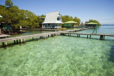 Jetty in the clear water and a typical wooden house on the small Caribbean island of Coral Key, Bocas del Toro, Panama, Central America