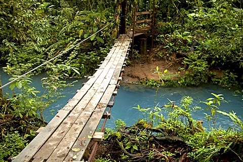 Suspension bridge over the blue waters of the Rio Celeste in Volcan Tenorio National Park, Costa Rica, Central America