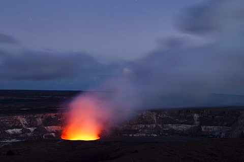 Magma in the Halema'uma'u Crater in the Kilauea Caldera illuminating the rising sulfur dioxide plume against the evening sky, Hawai'i Volcanoes National Park, Hawai'i, USA