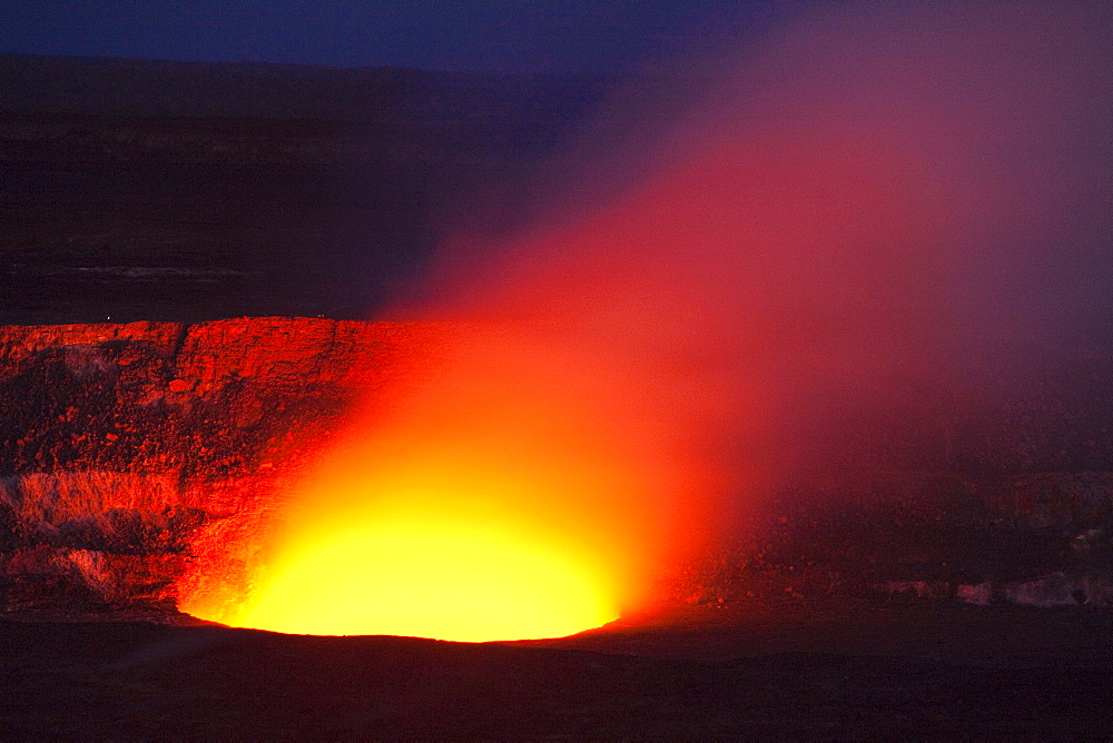 Magma in the Halema'uma'u Crater in the Kilauea Caldera illuminating the rising sulfur dioxide plume against the evening sky, Hawaii Volcanoes National Park, Hawaii, USA