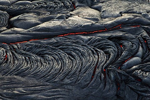 Molten pahoehoe type lava flowing from a crack in the East Rift Zone towards the sea, lava field of the Kilauea shield volcano, Hawai'i Volcanoes National Park, Kalapana, Hawai'i, USA