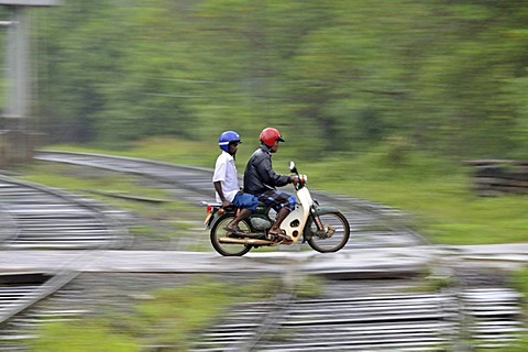 Moped riders in heavy rain, railway crossing in Kalawewa, Sri Lanka, Ceylon, South Asia, Asia, PublicGround