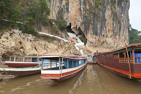 Ferry boats in front of holy caves of Pak Ou along the Mekong river, housing thousands of Buddha images, Luang Prabang, Laos, Southeast Asia