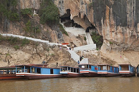 Ferry boats in front of holy caves of Pak Ou along the Mekong river, housing thousands of Buddha images, Luang Prabang, Laos, Southeast Asia