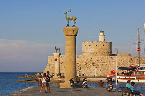 Elafos and Elafina, stag and doe sculptures on columns, with Agios Nikolaos fortress tower, Mandraki harbour, Rhodes, Greece, Europe, PublicGround