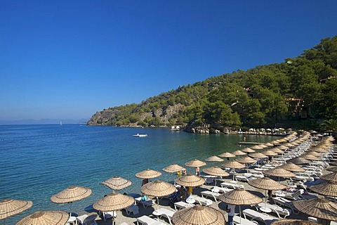 Deck chairs and parasols on the beach of the Hillside Club near Fethiye, Turkish Aegean Coast, Turkey