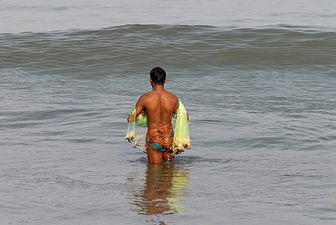 Fisherman with a net standing in the water, near Beypore, Kerala, Malabar Coast, southern India, Asia