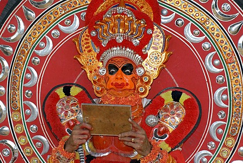 Theyyam performer looking into a mirror, moment of initiation, during a Theyyam ritual, near Kasargod, North Kerala, South India, Asia