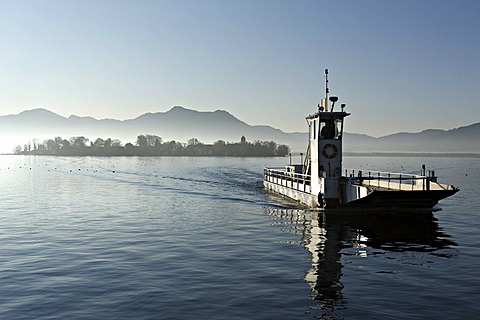 Vehicle transport boat and Fraueninsel island in early morning light, lake Chiemsee, Chiemgau, Upper Bavaria, Germany, Europe