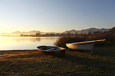 Dinghy boats on foreshore at sunrise, lake Chiemsee, Chiemgau, Upper Bavaria, Germany, Europe