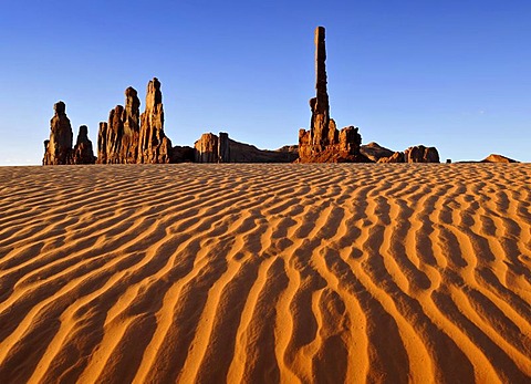 Sand dunes in front of the Totem Pole and Yei Bi Chei rock formations after sunrise, Monument Valley, Navajo Tribal Park, Navajo Nation Reservation, Arizona, Utah, United States of America, USA