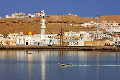 White mosque with a golden dome at the blue lagoon in the port city of Sur, Sultanate of Oman, Middle East