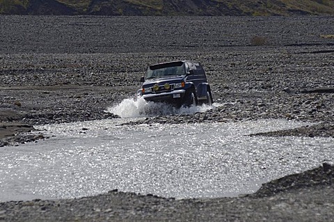 Super jeep driving in the river bed of the Krossa River, ï¬orsmoerk, Iceland, Europe