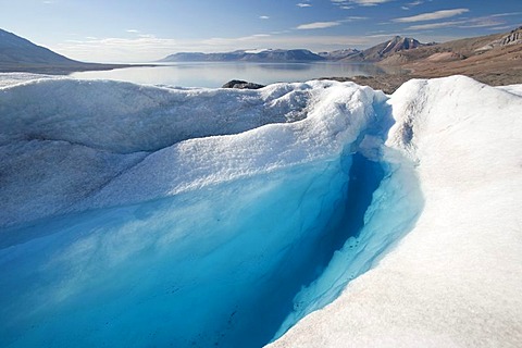 A water-filled crevasse of Nordenskioeldbreen Glacier with Billefjord at back, Spitsbergen, Svalbard, Norway, Scandinavia, Europe