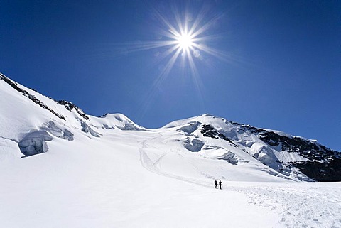 Hikers on the way down from Piz Palue Mountain in a glacial landscape, looking towards the summit of Piz Palue Mountain, Grisons, Switzerland, Europe