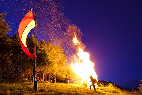 Fire on Kleiner Penegal mountain above Kaltern, Sacred Heart-Fire, with the flag of Tyrol, province of Bolzano-Bozen, Italy, Europe