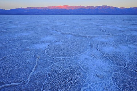 Salt pan, salt crystals, sunrise in Badwater Basin above Panamint Range, Death Valley National Park, Mojave Desert, California, USA