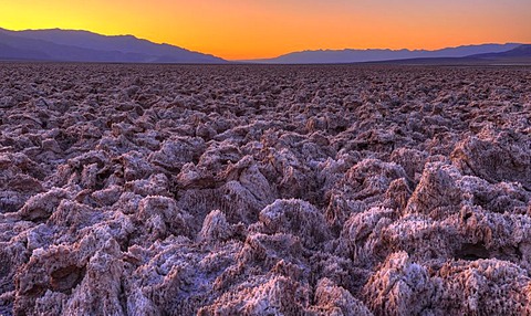 Spectacular lighting after sunset, salt crust on the Devil's Golf Course, Panamint Range, Black Mountains, Death Valley National Park, Mojave Desert, California, United States of America, USA