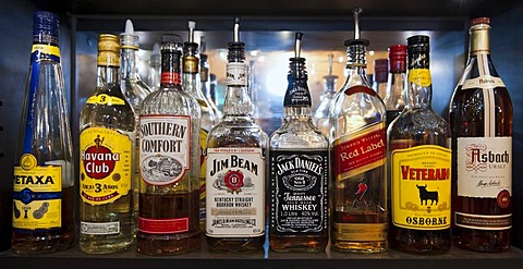 Bottles of various spirits standing on the shelf in a bar