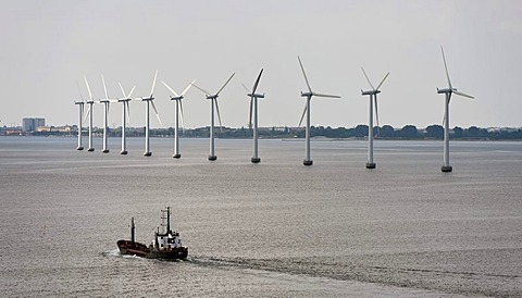 Cargo ship sailing in front of an offshore wind farm in the oresund outside Copenhagen, Denmark, Europe