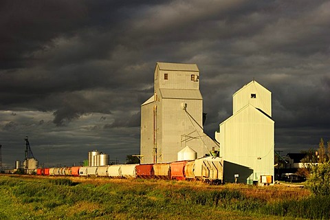 Typical granary with train and storm clouds, Manitoba, Canada