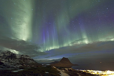 Rare purple-blue Northern Lights (Aurora borealis) above the Mt. Kirkjufell and Grundarfjoerï£¿ur city, SnÃŠfellsnes, Iceland, Europe