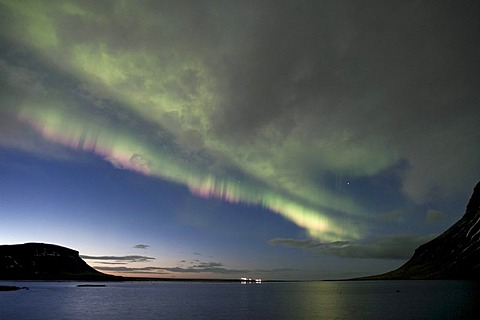 Pink-colored Northern Lights (Aurora borealis) at dusk behind a few clouds in Grundarfjoerï£¿ur SnÃŠfellsnes, Iceland, Europe