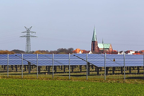 Solar power plant in a field in front of Meldorfer Cathedral, photovoltaic system, Meldorf, Dithmarschen, Schleswig-Holstein, Germany, Europe