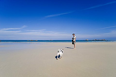 Woman with a Jack Russell on the beach near Kerbrat, Cleder, Finistere, Brittany, France, Europe