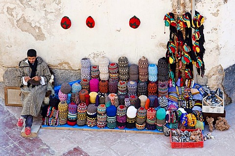 Man knitting and selling typical colourful Berber woollen hats in the historic town or medina, UNESCO World Heritage Site, Essaouira, Morocco, Africa