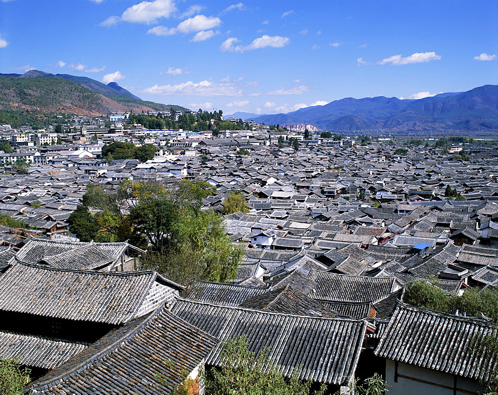 Ancient rooftops and traditional architecture of the Old Town, with Yulong Mountains in the background, Lijiang, UNESCO World Heritage Site, Yunnan Province, China, Asia