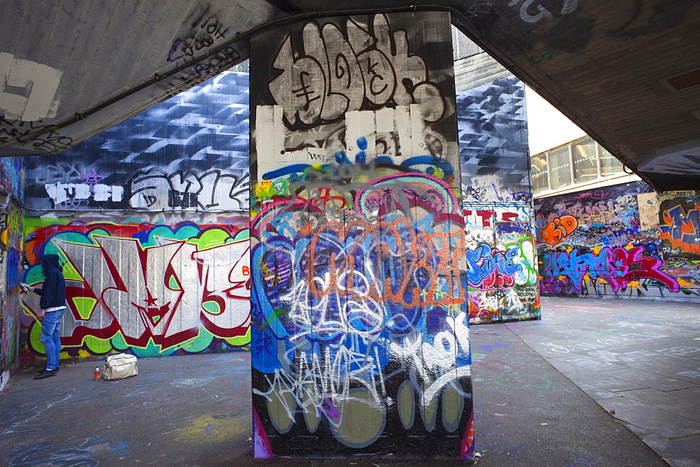 Graffiti artist at work under the Queen Elizabeth Hall, Southbank, London, England, United Kingdom, Europe