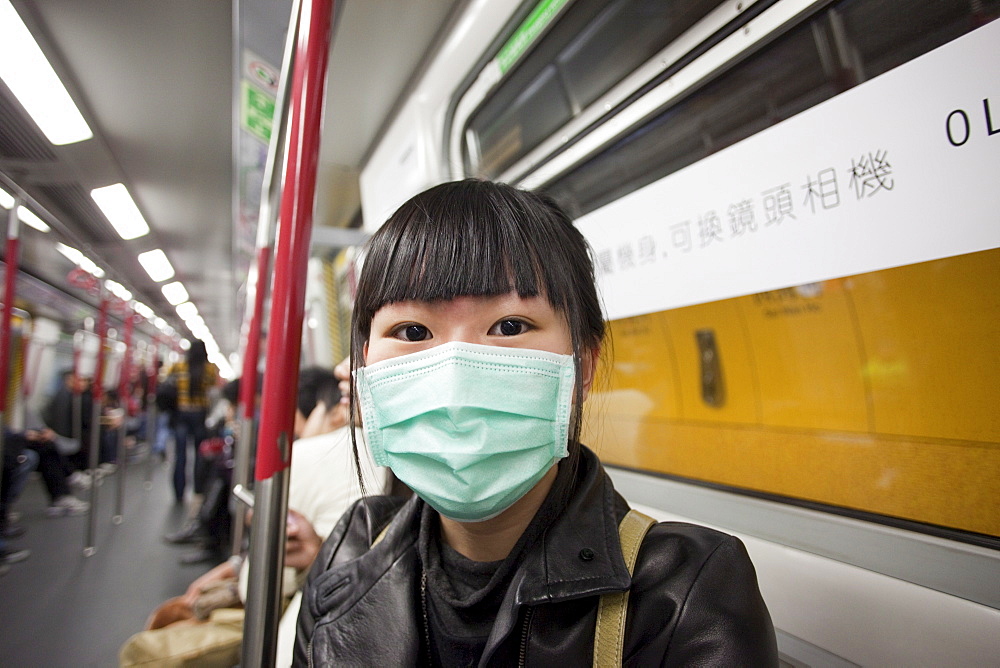 Girl on Subway wearing flu mask, Hong Kong, China, Asia