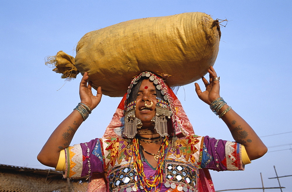 Gypsy woman carrying sack on head, Goa, India, Asia