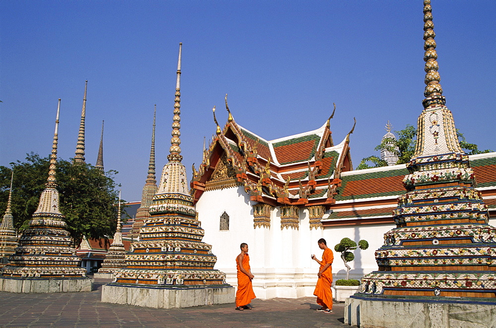 Monks walking past chedis, Wat Pho, Bangkok, Thailand, Southeast Asia, Asia