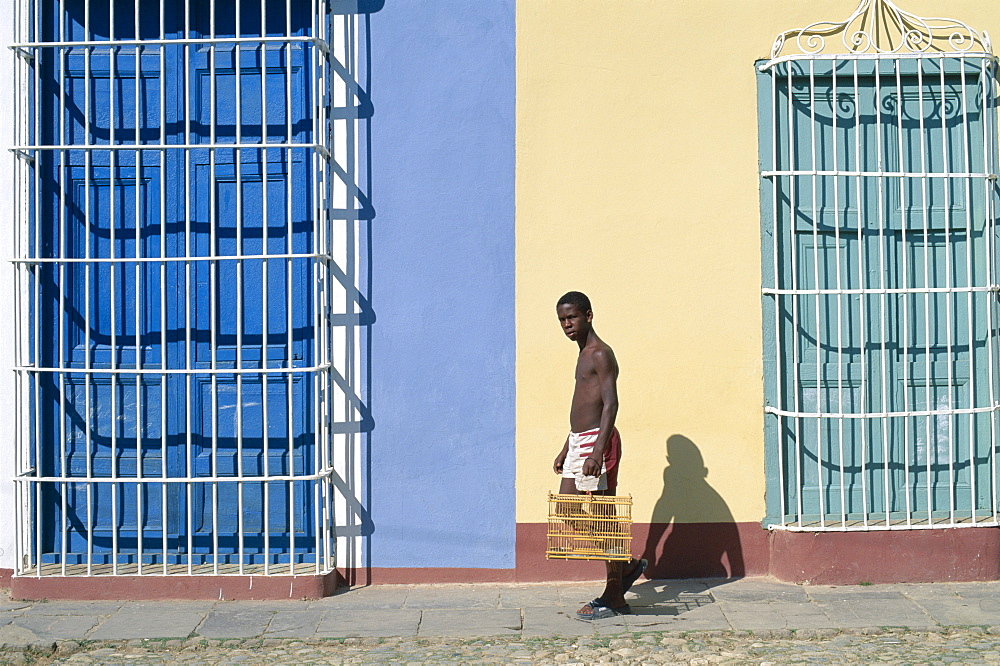 Man walking past colonial grille windows, Trinidad, UNESCO World Heritage Site, Cuba, West Indies, Central America