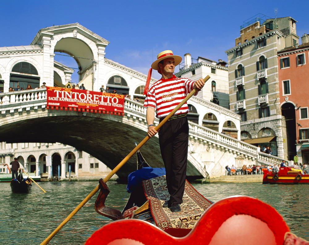 Gondolier on the Grand Canal (Canal Grande) by the Rialto Bridge (Ponte di Rialto), Venice, UNESCO World Heritage Site, Veneto, Italy, Europe