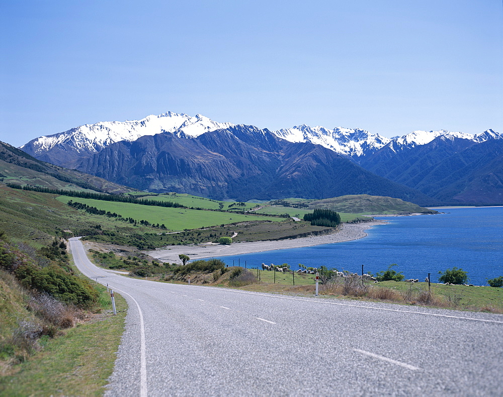 Empty road beside lake with the Southern Alps in the background, South Island, New Zealand, Pacific