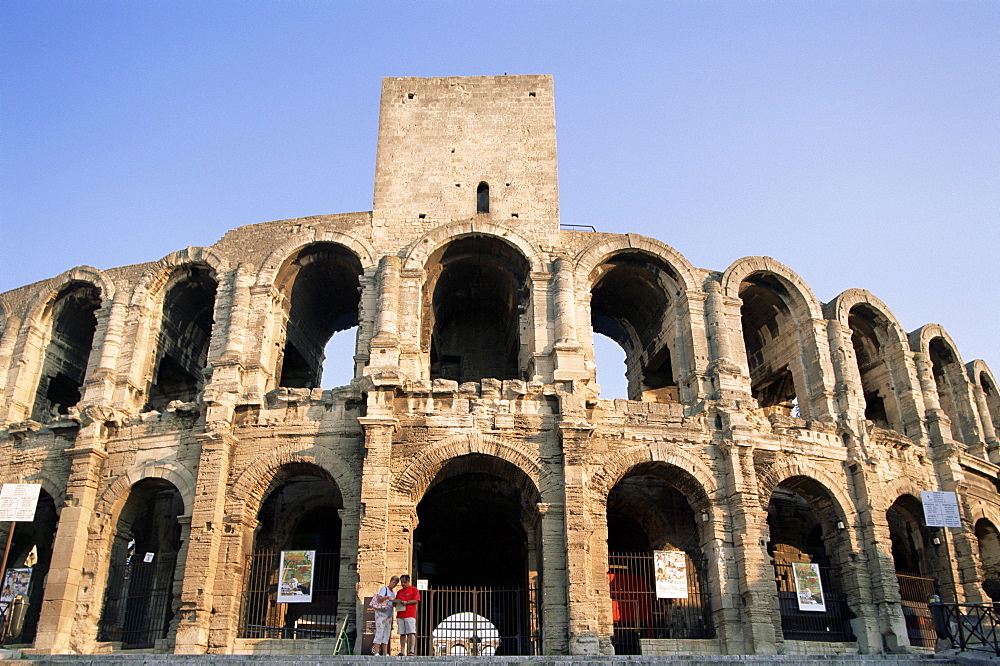 Couple looking at map in front of Roman amphitheatre, UNESCO World Heritage Site, Arles, Provence, France, Europe