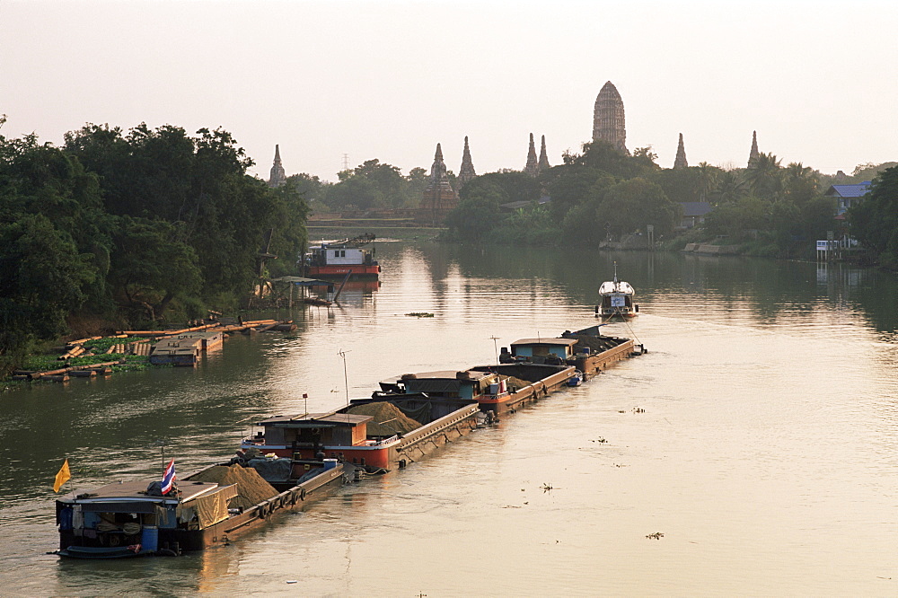 Barges on Chao Phraya River and Wat Chai Wattanaram in background, Ayutthaya Historical Park, Ayutthaya, Thailand, Southeast Asia, Asia