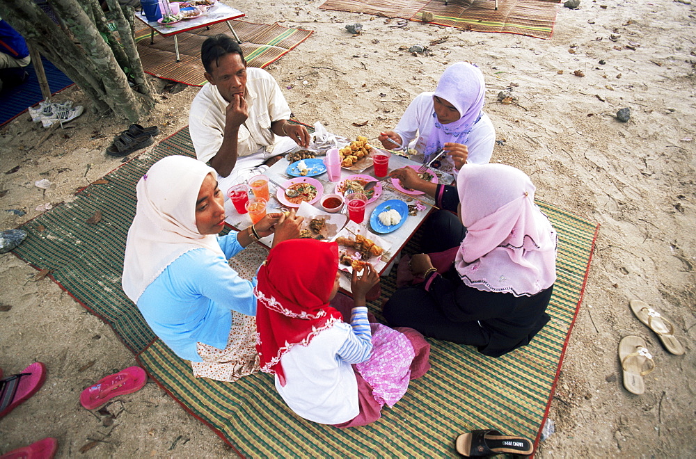 Muslim family eating on beach, Krabi, Thailand, Southeast Asia, Asia