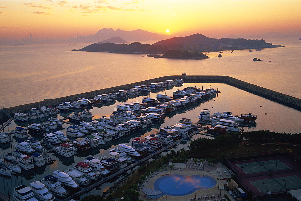 Sunrise over Peng Chau Island with Discovery Bay Marina in foreground, Hong Kong, China, Asia