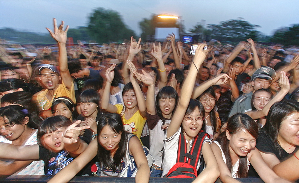 Young Chinese persons cheering at a rock and roll concert, Beijing, China, Asia