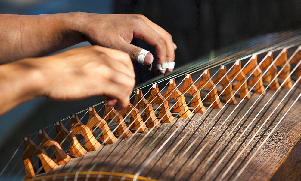 Closeup of two hands playing the guzheng, a traditional Chinese string instrument, Beijing, China, Asia