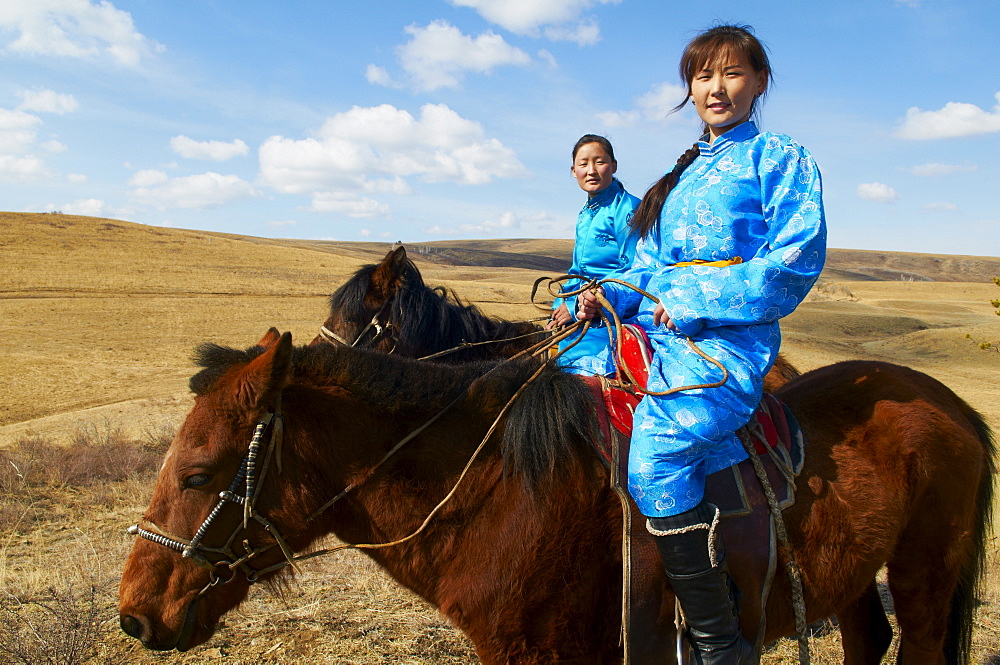 Young Mongolian women in traditional costume (deel) riding horses, Province of Khovd, Mongolia, Central Asia, Asia