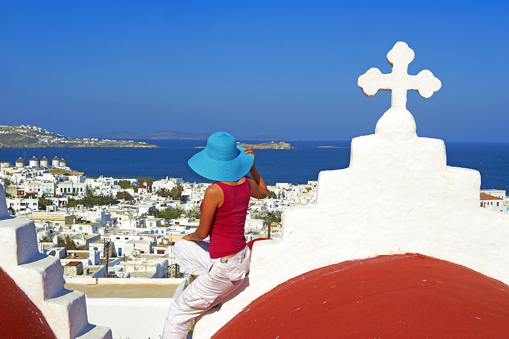 Tourist on roof of red church above the old town, Mykonos town, Chora, Mykonos, Cyclades, Greek Islands, Greece, Europe