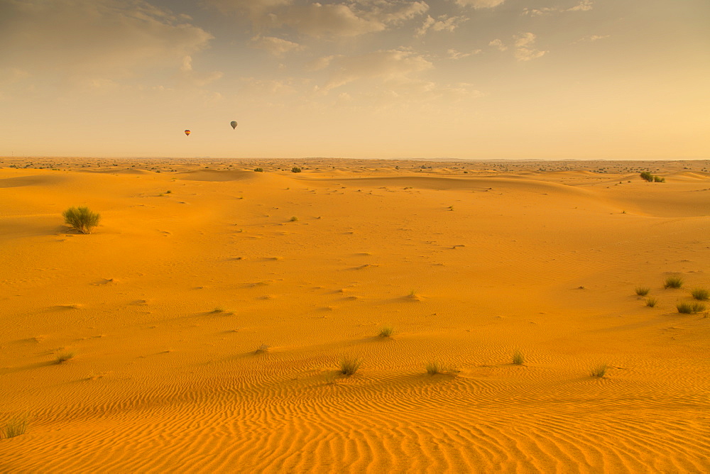 Hot air balloons over sand dunes at sunrise in the Dubai Desert, Dubai, United Arab Emirates, Middle East