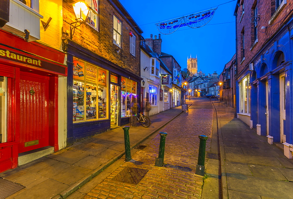 View of illuminated Lincoln Cathedral viewed from the cobbled Steep Hill at dusk, Lincoln, Lincolnshire, England, United Kingdom, Europe