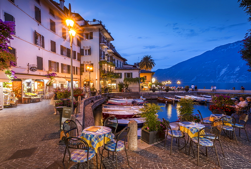 View of illuminated promenade at the port of Limone at dusk, Lake Garda, Lombardy, Italian Lakes, Italy, Europe